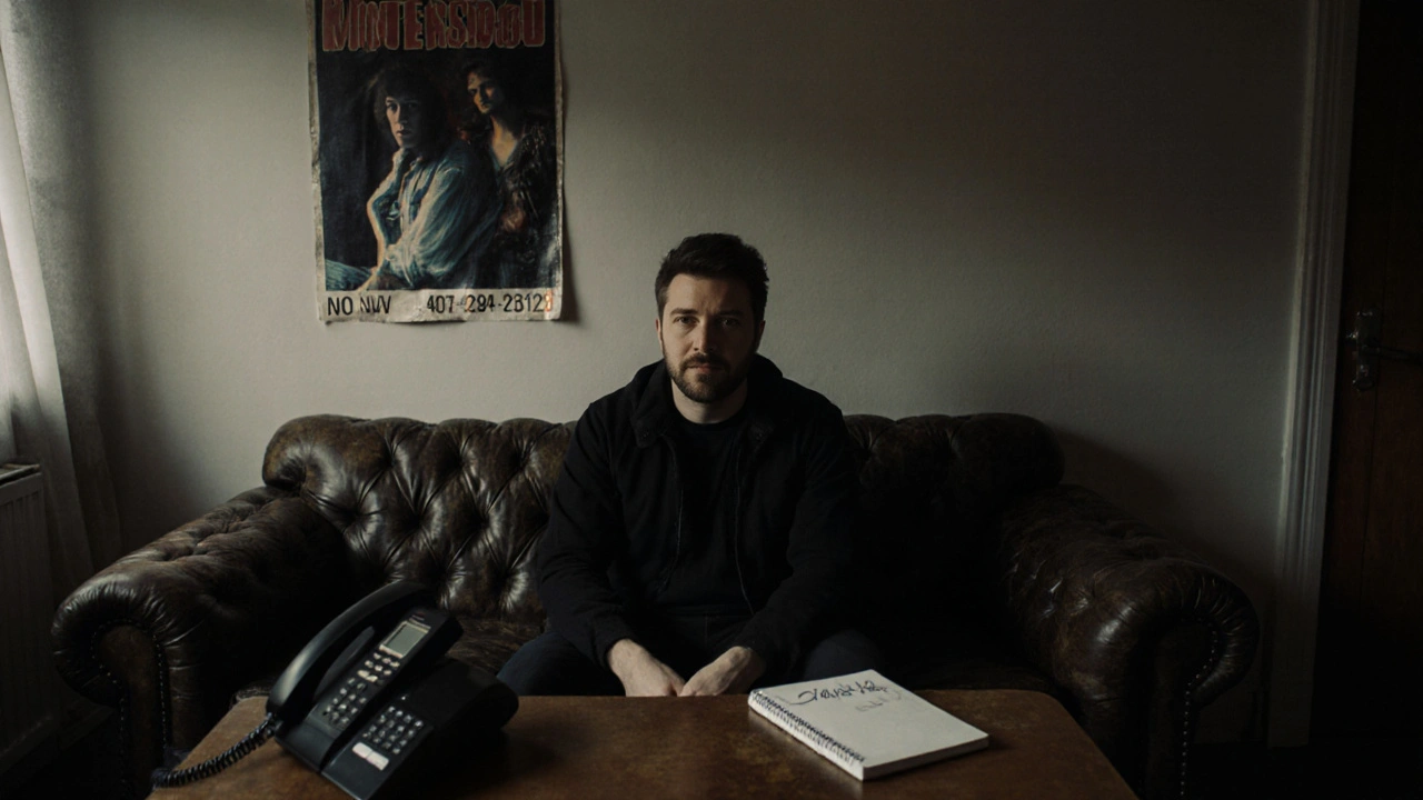 Man sitting alone in a modest private agency office with a phone and notebook
